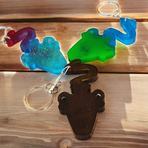 A handcrafted resin keyring featuring an Aquarius zodiac sign in three different colours