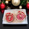 Set of two British- themed Christmas baubles featuring a royal guard and London taxi in red and gold.
