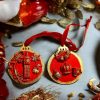 handcrafted Christmas tree ornaments with a red background and gold accents, featuring designs of Big Ben and British crown with holiday motifs.