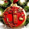 handcrafted Christmas tree ornaments with a red background and gold accents, featuring designs of Big Ben and British crown with holiday motifs.