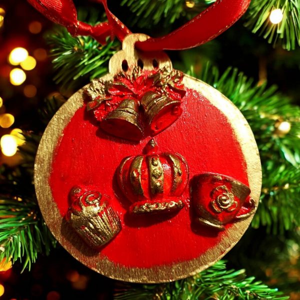 handcrafted Christmas tree ornaments with a red background and gold accents, featuring designs of Big Ben and British crown with holiday motifs.