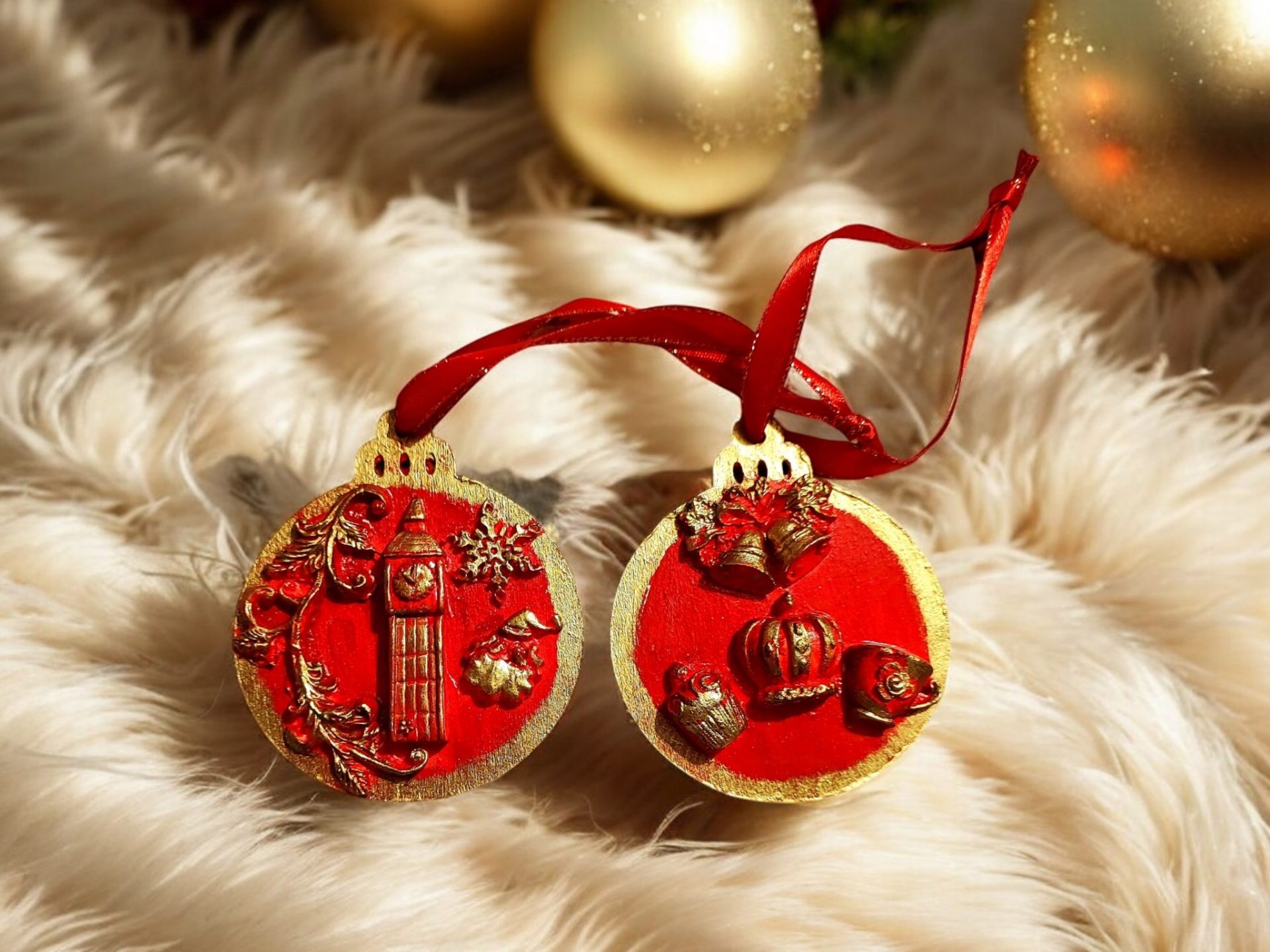 Two handcrafted Christmas tree ornaments with a red background and gold accents, featuring designs of Big Ben and British crown with holiday motifs.