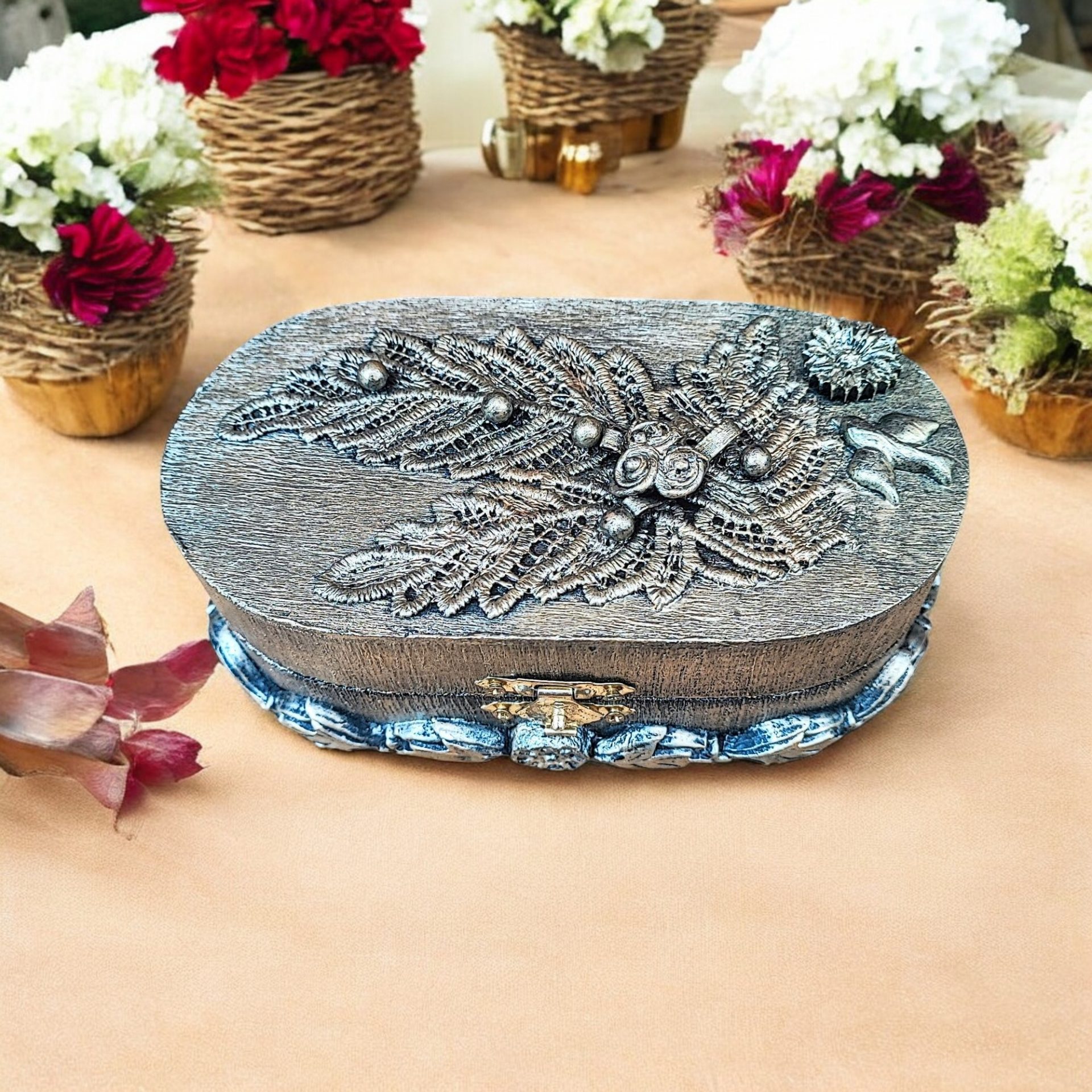 Handcrafted oval trinket box with antique-style metallic floral and leaf detailing, featuring a decorative clasp and sturdy design.