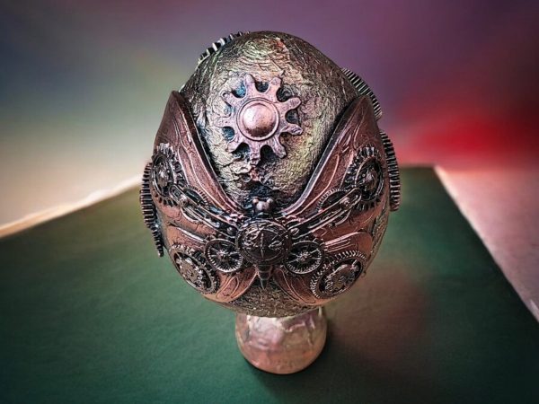 Handcrafted steampunk decorative egg with copper accents, gears, and a vintage-style pedestal base, perfect for home décor or as a unique gift