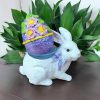 Handcrafted decorative egg with floral details on a bunny stand